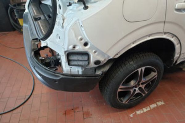 PKW-Unfallgutachten . Kasko 600 x 400 Pkw mit demontierter Frontverkleidung und freigelegtem Kotflügel in der Werkstatt